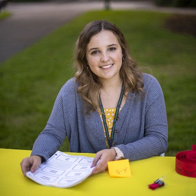 Friendly student sitting at a yellow table.